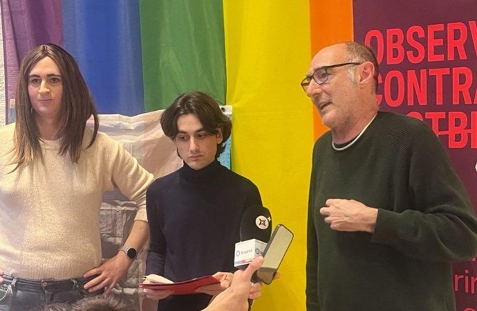 La activista trans Jordina Mora; el responsable del registro de incidencias del Observatori contra la LGBTIfòbia, Albert Carrasco; y el presidente del Observatori, Eugeni Rodríguez, en la rueda de prensa del jueves