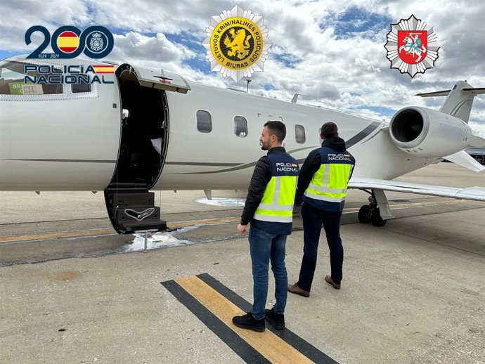 Agentes de la Policía Nacional frente a un avión.