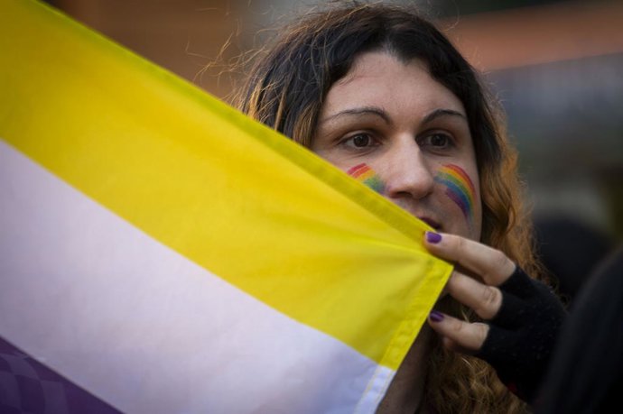 Uma pessoa mostra uma bandeira durante uma manifestação para denunciar ataques à comunidade transgênero internacionalmente, da Plaza Pedro Zerolo à Plaza de Callao, em 29 de março de 2025, em Madri, Espanha. A Federação Plataforma Tran