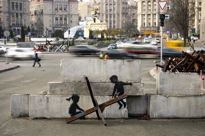 Archivo - HANDOUT - 12 de novembro de 2022, Ucrânia, ---: Uma foto de divulgação sem data que o artista de rua Banksy postou em seu canal do Instagram mostra uma barreira de tanques. Em um bloco de concreto atrás dela estão duas crianças que parecem estar
