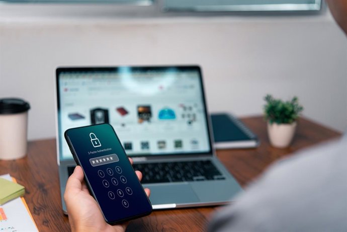 Archivo - Teléfono móvil y portátil.