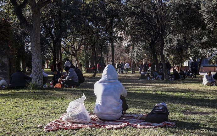 Archivo - Varias personas comen durante el reparto de alimentos a personas sin recursos, en el viejo cauce del río Turia, a 19 de diciembre de 2023, en Valencia, Comunidad Valenciana (España). Imagen de archivo.