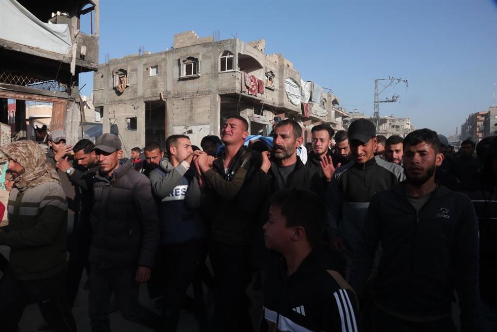 Varias personas llevan el cuerpo de un periodista fallecido en un ataque de Israel contra el norte de la Franja de Gaza (archivo) 