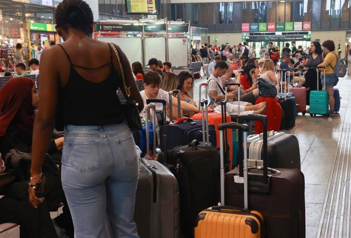 Archivo - Viajeros en la estación de Santa Justa esperan a coger sus trenes en una foto de archivo.