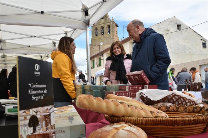 La diputada de Promoción provincial, Magdalena Rodríguez, y el presidente de la Diputación, Miguel Ángel de Vicente, visitan un puesto de una feria de 'Alimentos de Segovia'.