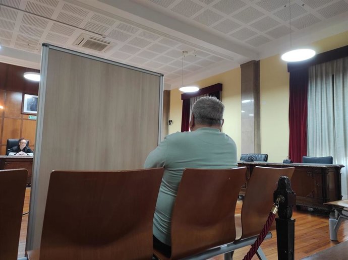 El acusado, sentado en el banquillo y separado por un biombo, escucha la declaración de su exmujer