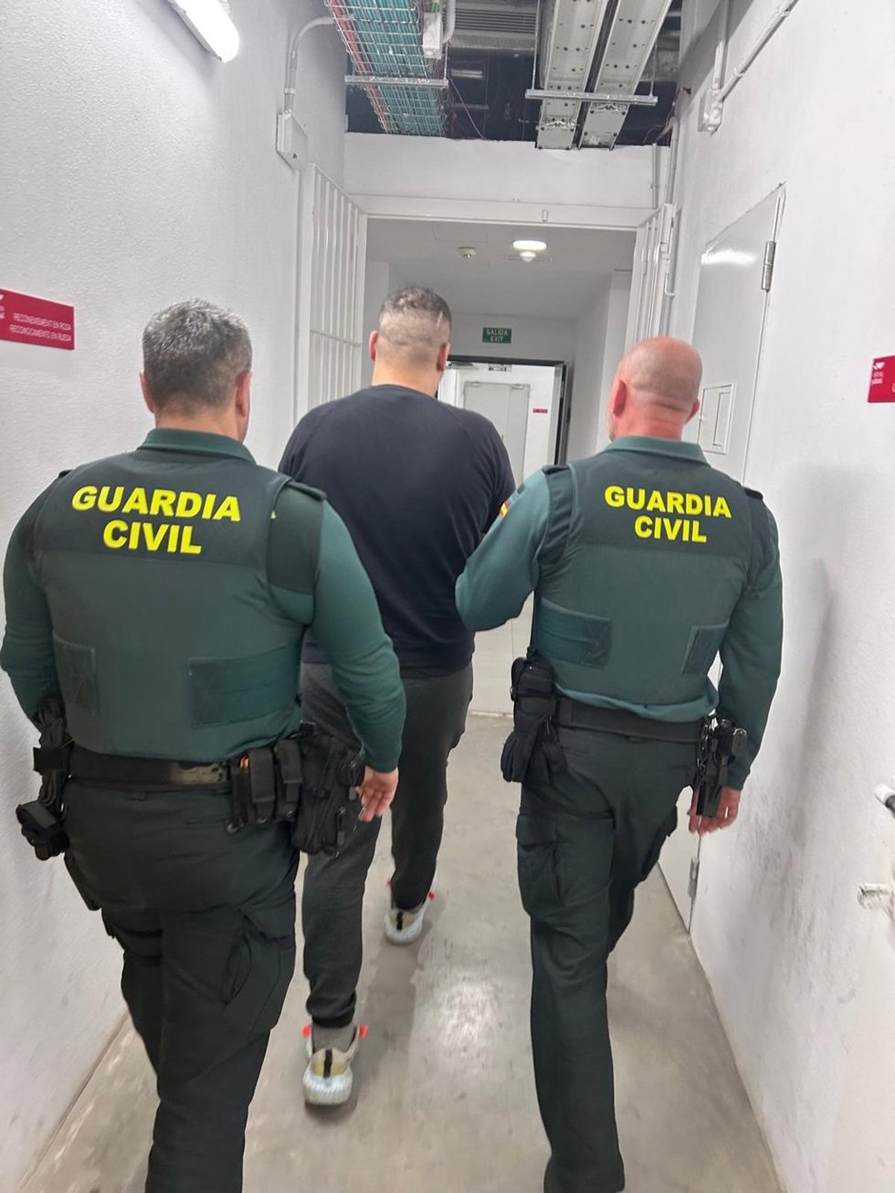 Uno de los detenidos, conducido por agentes.