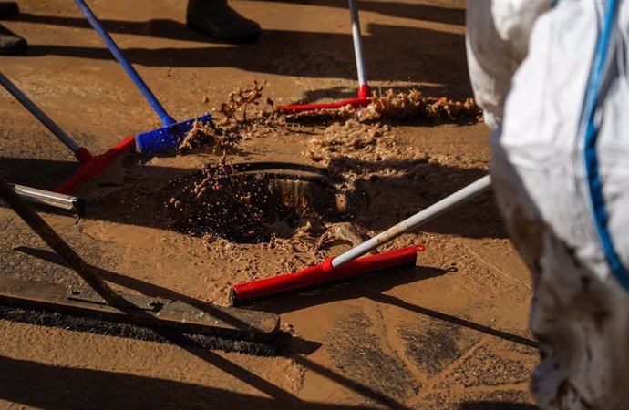 Archivo - Varias personas realizan labores de limpieza en Paiporta tras la dana en imagen de archivo