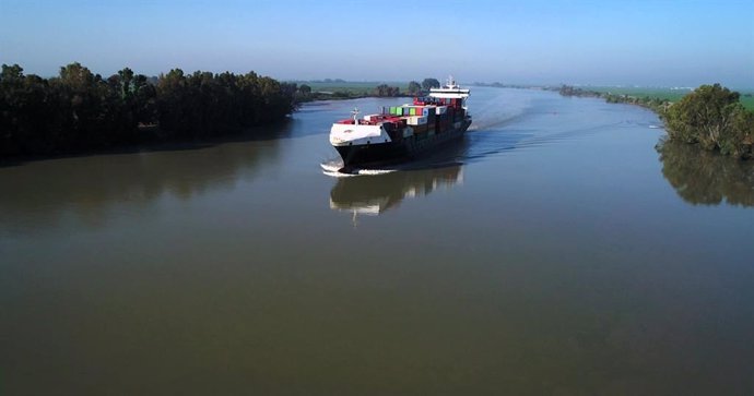 Un buque navega por aguas del Guadalquivir al paso por Sevilla.
