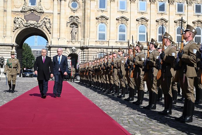 HANDOUT - 03 de abril de 2025, Hungria, Budapeste: O primeiro-ministro húngaro Viktor Orban cumprimenta o primeiro-ministro israelense Benjamin Netanyahu (à direita) em sua chegada a Budapeste. Essa é a primeira viagem de Netanyahu à Europa desde a emissã
