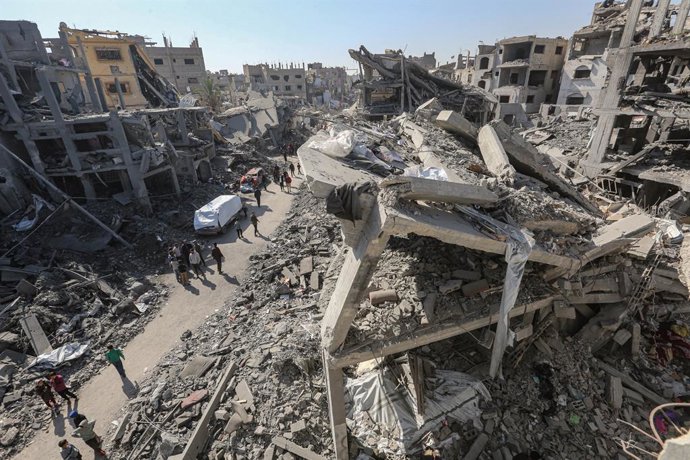Palestinos ao lado de edifícios destruídos por bombardeios do exército israelense no bairro de Shujaia, no leste da Cidade de Gaza, no norte da Faixa (arquivo).