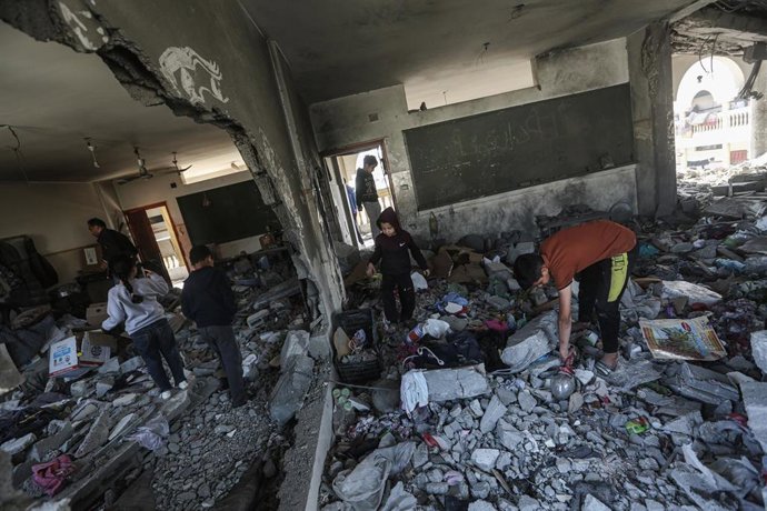 Palestinos inspeccionan una escuela en Gaza, destruida por ataques isrelíes (archivo)