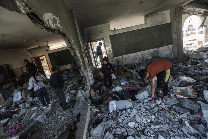 18 de março de 2025, Cidade de Gaza, Faixa de Gaza, Território Palestino: Palestinos inspecionam uma área destruída da escola Al Tabien após ataques aéreos israelenses na Cidade de Gaza, em 18 de março de 2025. Em 18 de março, as forças israelenses confir