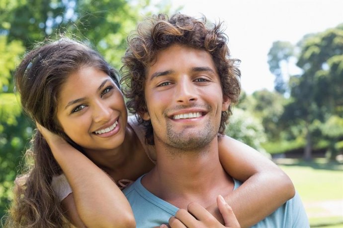 Dos personas sonríen a la cámara.