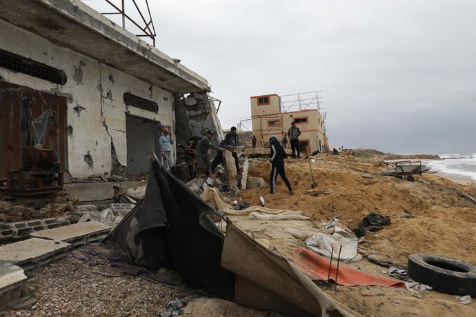 Palestinos em frente a um prédio bombardeado pelo exército israelense em Deir al-Bala'a, na região central da Faixa de Gaza (arquivo).