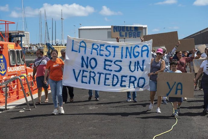 Varias personas durante una manifestación en contra de que instalaciones de acogida de personas migrantes en el puerto de La Restinga