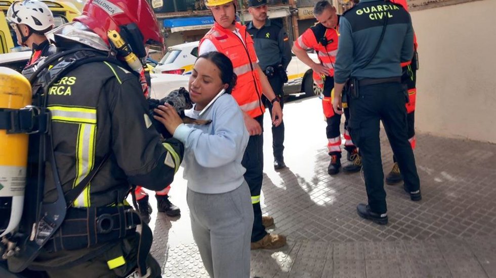 Un bombero devuelve a su propietaria el gato rescatado de un incendio.