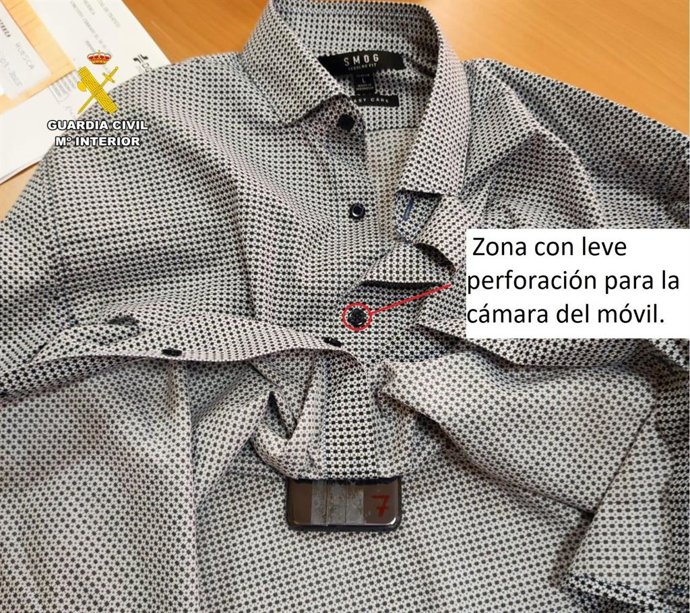 Camisa con un agujero oculto a la altura de un botón empleada por uno de los examinantes del teórico de conducir denunciado por el empleo de dispositivos de comunicación.
