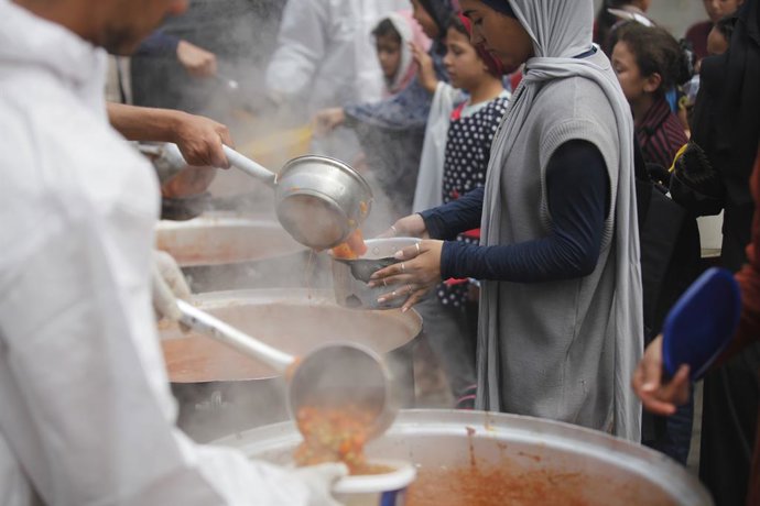 5 de abril de 2025, Nusairat, Faixa de Gaza, Território Palestino: Palestinos, incluindo mulheres e crianças, lutam para coletar alimentos durante uma distribuição da organização de caridade no Campo de Refugiados de Nusairat, no norte da Cidade de Gaza, 