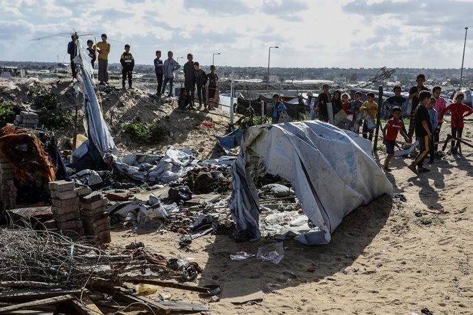 Palestinos ao lado de barracas destruídas pelo bombardeio do exército israelense em Khan Younis, no sul da Faixa de Gaza (arquivo)