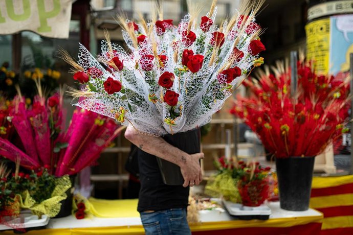 Archivo - Un hombre con rosas decenas de rosas rojas el día de Sant Jordi 2024.
