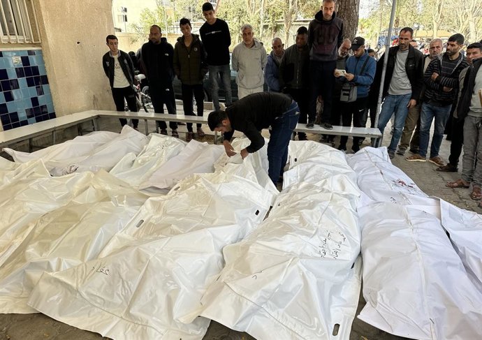 Palestinos xunto a los cuerpos de los muertos por un ataque del Exércitu d'Israel contra delles tiendes de campaña usaes por movíos en Jan Yunis, nel sur de la Franxa de Gaza (arquivu).  