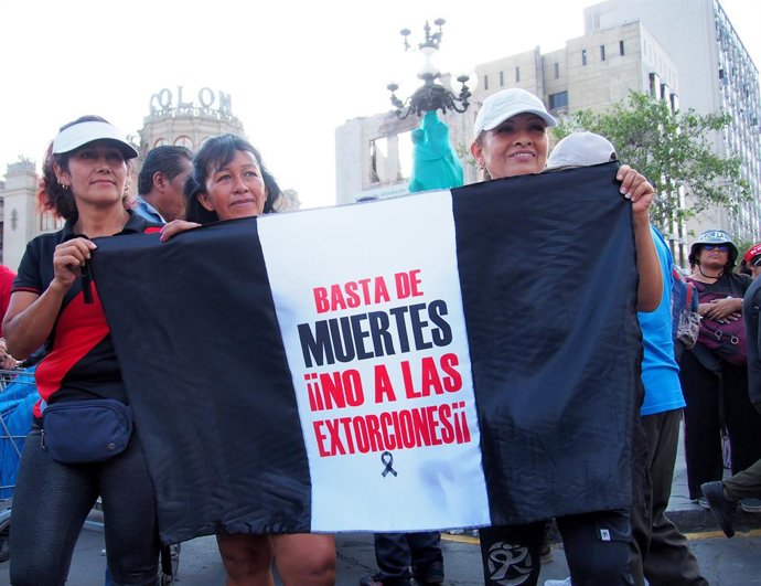 21 de março de 2025, Lima, Lima, Peru: "Chega de mortes, não à extorsão" pode ser lido em uma bandeira preta do Peru quando centenas de pessoas saem às ruas para protestar contra a insegurança, a extorsão, os assassinatos e a incapacidade do governo de co