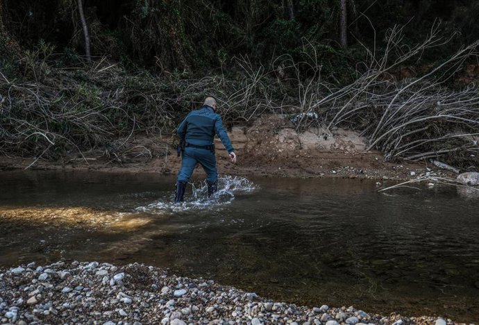 Archivo - Un agente de la Guardia Civil busca a un desaparecido en los barrancos del río Turia