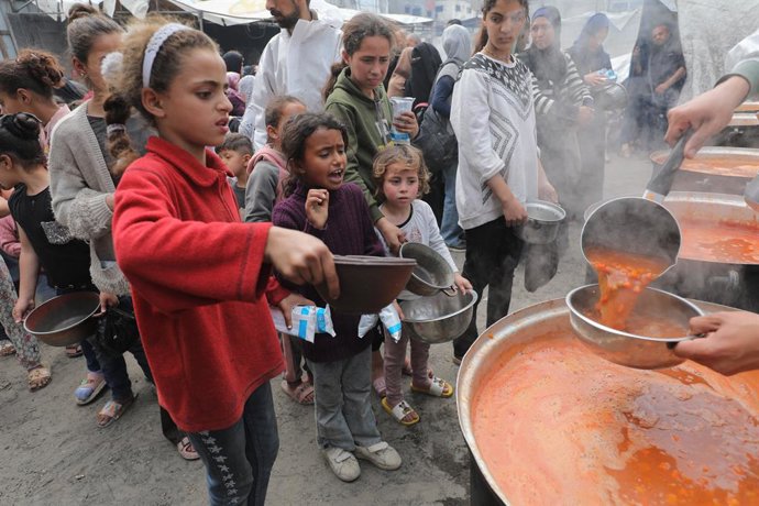 6 de abril de 2025, Nusairat, Faixa de Gaza, Território Palestino: Palestinos, incluindo mulheres e crianças, lutam para coletar alimentos durante uma distribuição da organização de caridade no Campo de Refugiados de Nusairat, no norte da Cidade de Gaza, 