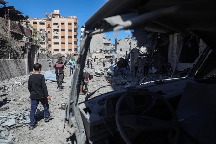 GAZA, 19 de março de 2025 -- Pessoas são vistas perto de um prédio destruído em um bombardeio israelense no bairro de Sabra, ao sul da Cidade de Gaza, em 19 de março de 2025. Pelo menos 25 palestinos foram mortos e dezenas de outros ficaram feridos na qua