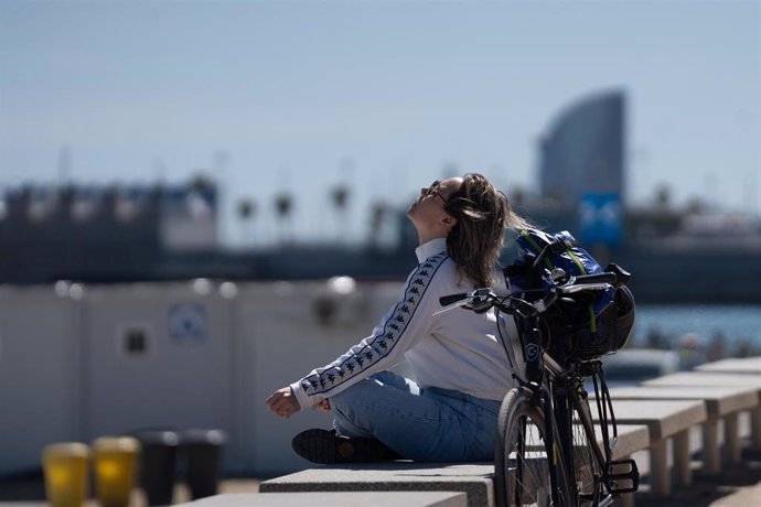 Archivo - Una mujer toma el sol en el paseo marítimo de la playa del Bogatell, a 15 de abril de 2024, en Barcelona, Catalunya (España). 