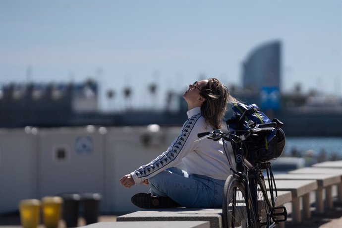 Archivo - Una mujer toma el sol en el paseo marítimo de la playa del Bogatell, a 15 de abril de 2024, en Barcelona, Catalunya (España). Catalunya ha registrado este 13 y 14 de abril un fin de semana "caluroso" para la época del año, con temperaturas diurn
