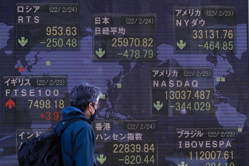Archivo - 24 February 2022, Japan, Tokyo: A man walks past an electronic stock exchange board displaying Japan's Nikkei stock index in downtown Tokyo. Japan's Nikkei index fell below 26,000 points on Thursday for the first time since November 2020 after