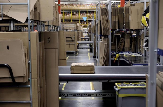 Archivo - Vista de una cinta mecánica y varias cajas de cartón en las instalaciones de un centro logístico de Amazon