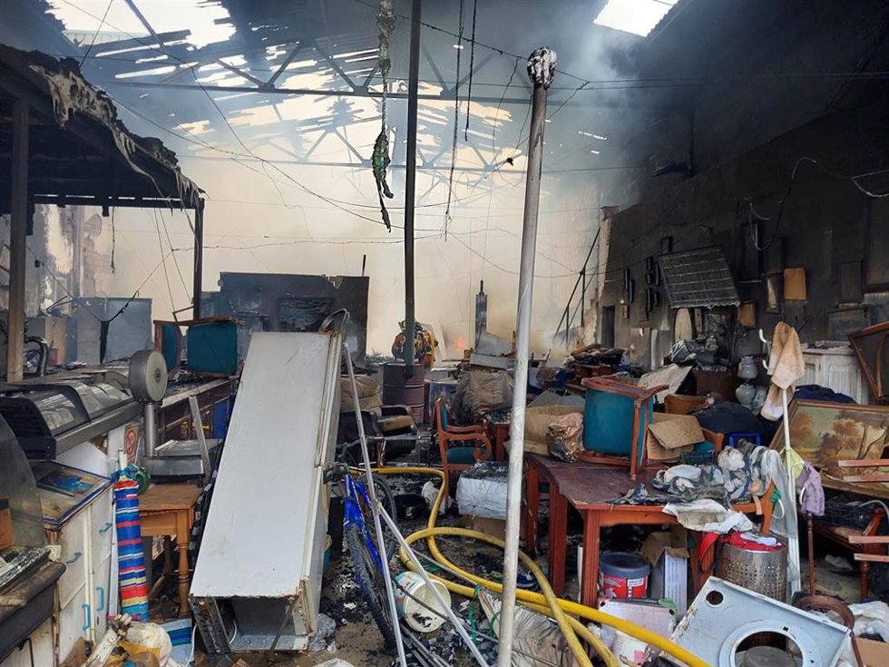 Imagen de la nave incendiada, situada en el término municipal de Moguer, durante las labores de extinción de los bomberos.