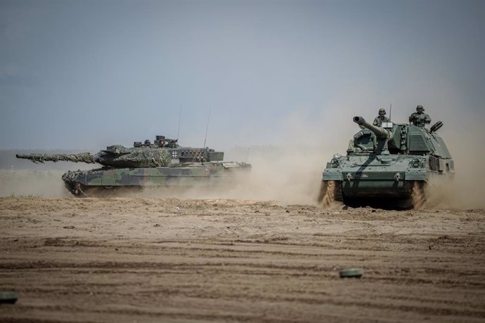 Archivo - 26 June 2023, Lithuania, Vilnius: A self-propelled howitzer 2000 (R) and a Leopard 2 main battle tank are in action during the NATO exercise "Griffin Storm".