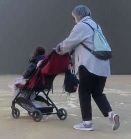 Archivo - Una mujer con un carrito de bebé en una imagen de archivo