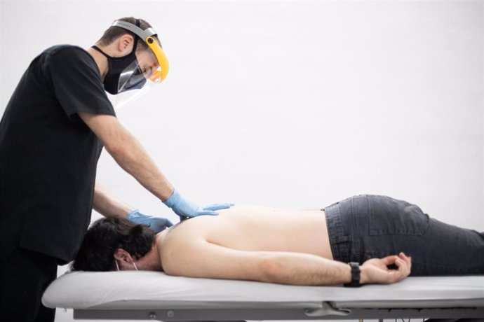Archivo - Un fisioterapeuta atiende a un cliente en su clínica en una foto de archivo de Europa Press
