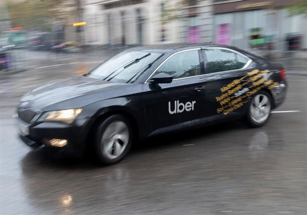 Archivo - Un vehículo con licencia VTC circula por una calle de Madrid
