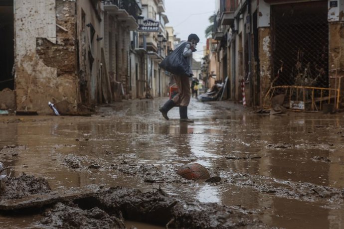 Archivo - Arxiu - Un home passeja pel carrer negat de fang, a 13 de novembre de 2024, a Paiporta