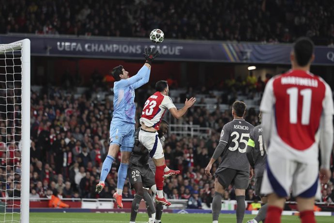Thibaut Courtois of Real Madrid and Mikel Merino of Arsenal in action during the UEFA Champions League 2024/25 Quarter Final First Leg match between Arsenal FC and Real Madrid C.F. at Arsenal Stadium on April 08, 2025 in London, England.