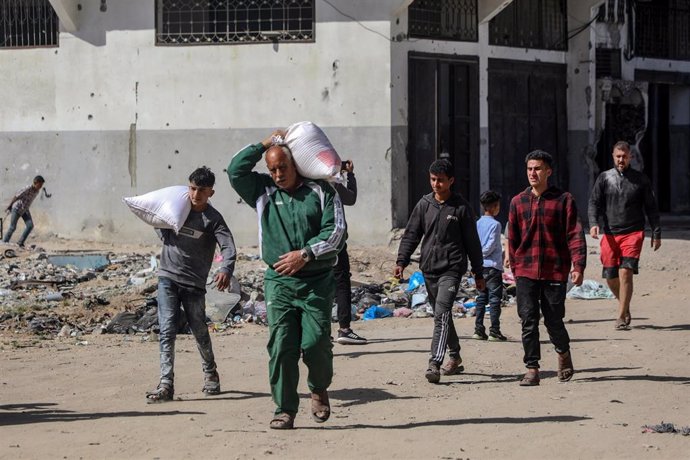 Grupo de palestinos llevan a hombros sacos de harina en el barrio de Tuffah, en ciudad de Gaza 