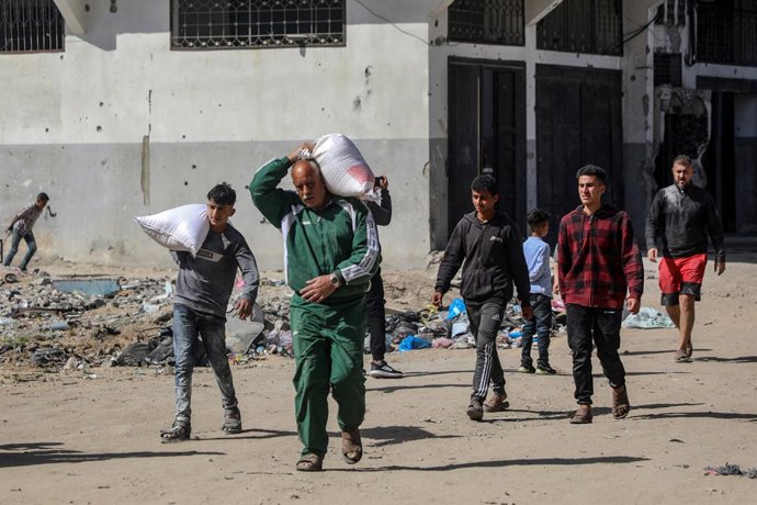 GAZA, 2 de abril de 2025 -- Palestinos carregam sacos de farinha no bairro de al-Tuffah, a leste da Cidade de Gaza, em 2 de abril de 2025. Todas as 25 padarias apoiadas pelo Programa Mundial de Alimentos das Nações Unidas (PMA) fecharam, anunciou a agênci