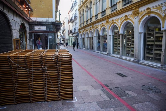 Líneas rojas pintadas en la calle Sierpes, junto a sillas apiladas para los abonados en esta zona de la Carrera Oficial.