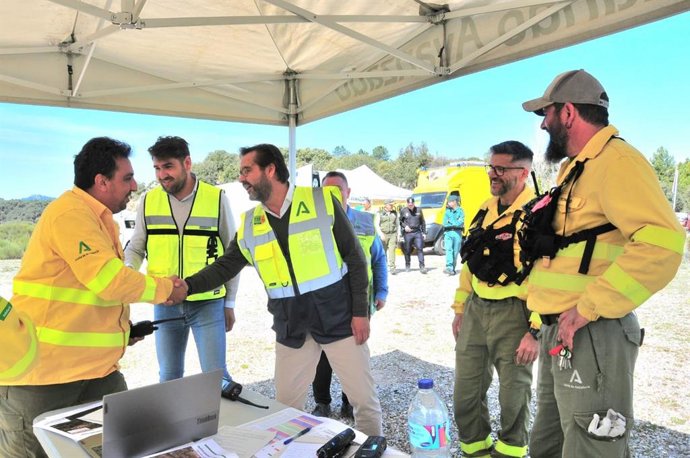 El delegado del Gobierno andaluz en Granada, Antonio Granados, en el centro en la imagen, saluda a un efectivo del operativo del simulacro en presencia del alcalde de Huétor Santillán, José Carlos Ortega, a su derecha