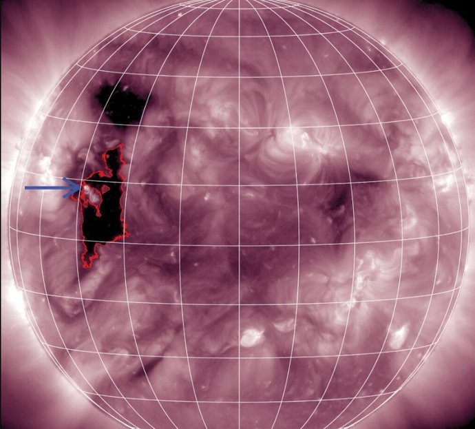 A seta azul marca um pequeno ponto brilhante na borda de um buraco coronal (delineado em vermelho) que foi a fonte do fenômeno.