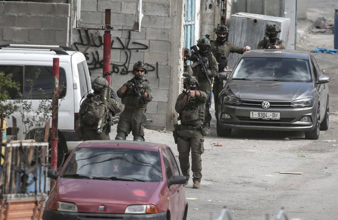 19 de março de 2025, Nablus, Cisjordânia: Soldados israelenses apontam suas armas durante uma incursão no campo de refugiados de Al-Ain, perto de Nablus, na Cisjordânia. As forças israelenses realizaram uma operação militar, invadindo casas palestinas e s