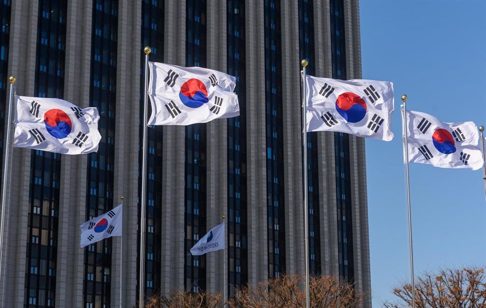 Archivo - Banderas de Corea del Sur frente al edificio que acoge la oficina del primer ministro en la capital, Seúl (archivo)