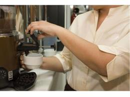 Archivo - Un cambrer prepara un cafè en un bar