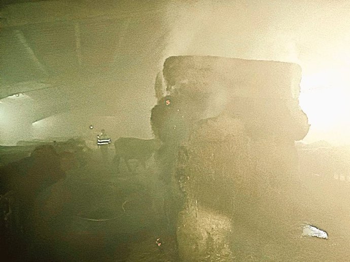 Los bomberos extienden el incendio de unas pacas en una estabulación de Sopeña